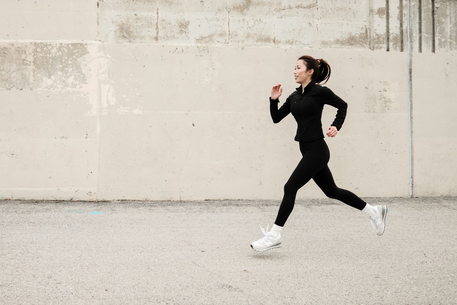 Runner adjusting a knee brace outdoors in bright daylight