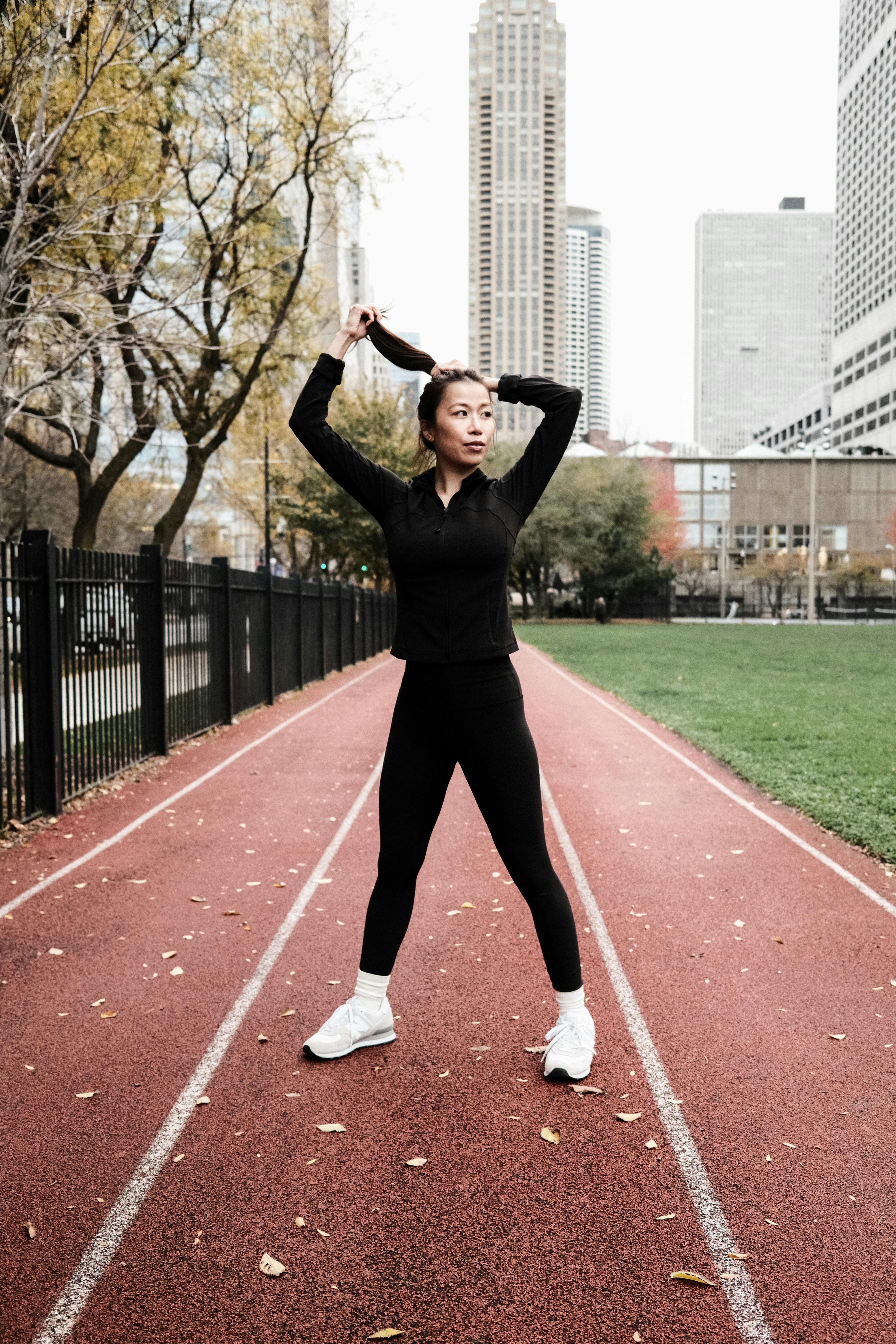 Woman tying running shoes, bright gym floor, morning sunlight, feeling motivated for a workout.