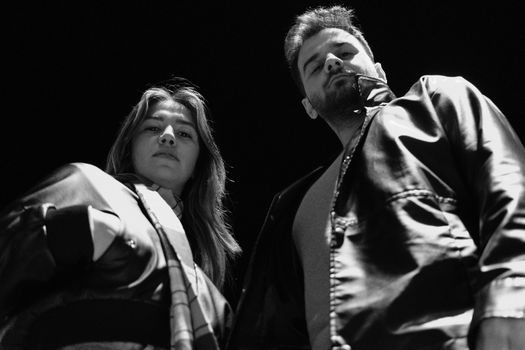 Bold low-angle shot of two individuals showcasing attitude and style.
