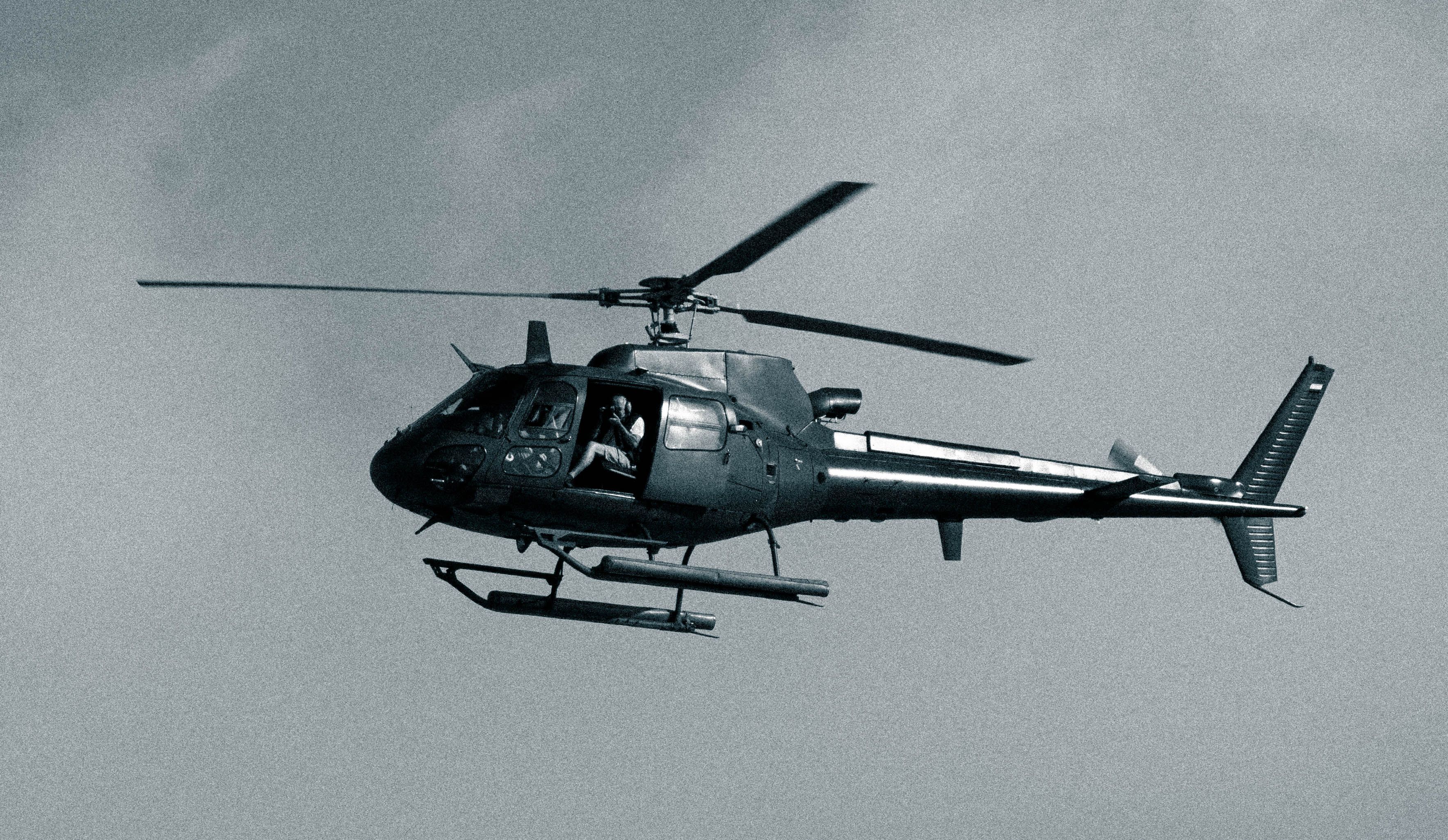 A black and white photo of a helicopter in flight, capturing the essence of aviation.