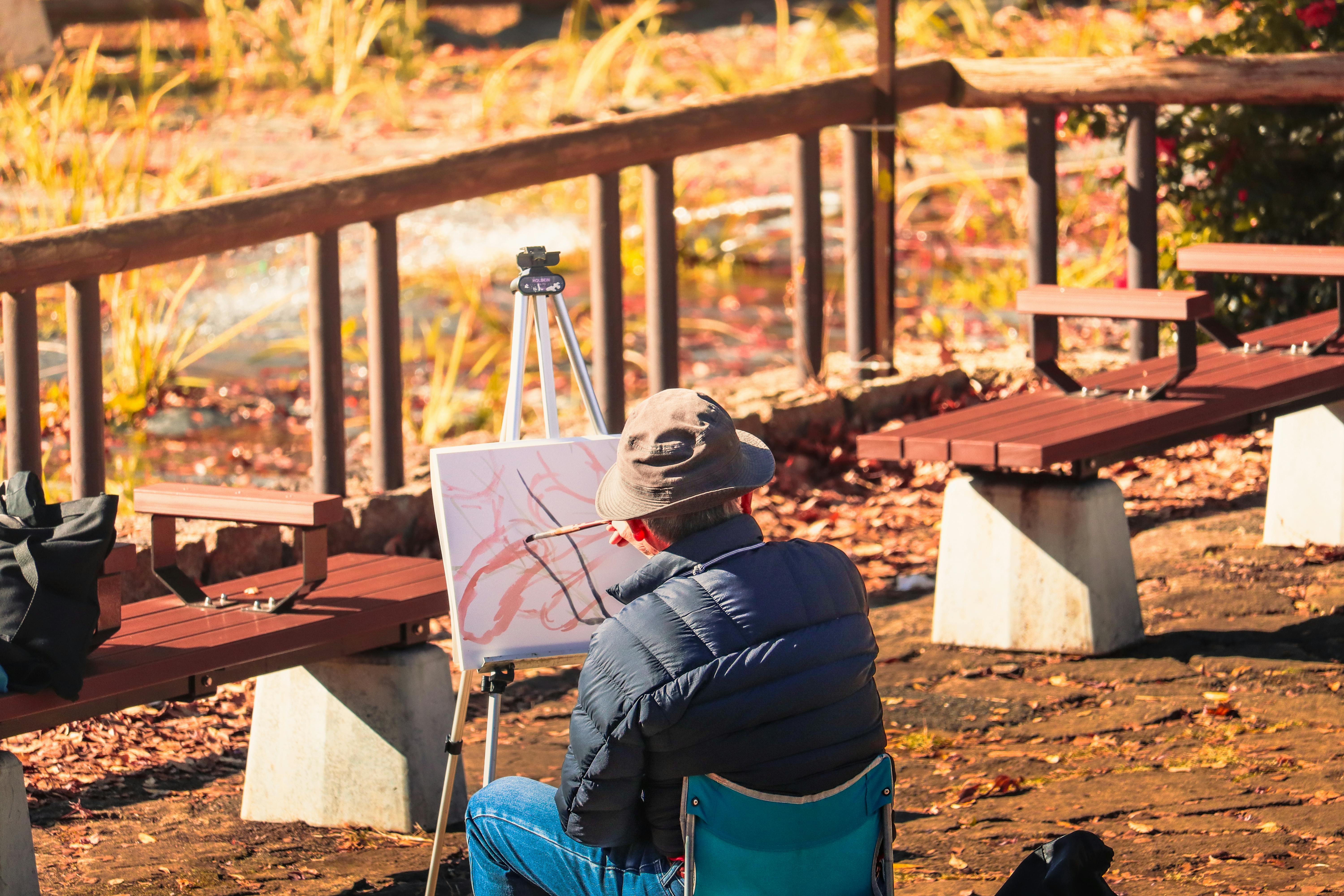 静かな東京の公園で、夢中で秋の風景を描くアーティスト。魅惑的な秋の色彩。