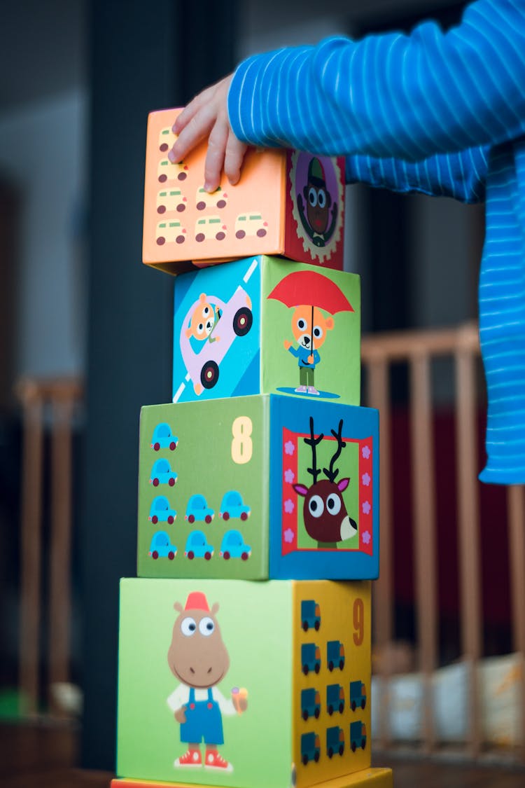 Person Holding Yellow And Pink Lego Blocks