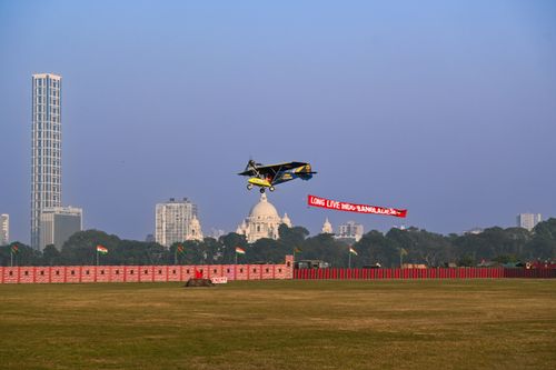 Free Airplane flying over Kolkata's skyline with a banner celebrating Indo-Bangladesh relations. Stock Photo