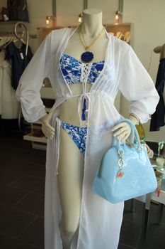 Mannequin showcasing trendy swimwear and accessories in a modern boutique setting.