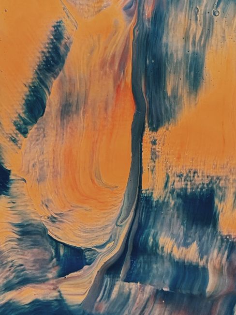 A vibrant abstract painting showcasing dynamic orange and blue swirls.