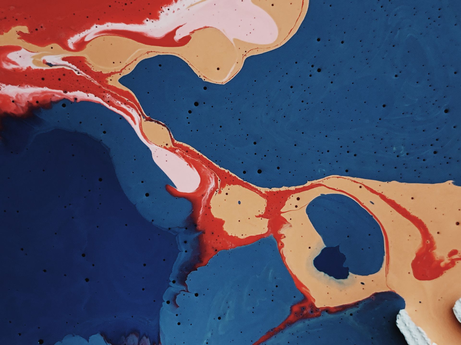 Vibrant abstract painting showcasing bold blue, red, and beige colors with fluid patterns and textures.