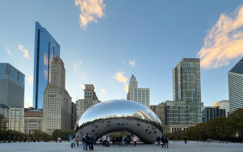 Free Beautiful view of Cloud Gate sculpture with Chicago skyline reflecting at sunset. Stock Photo