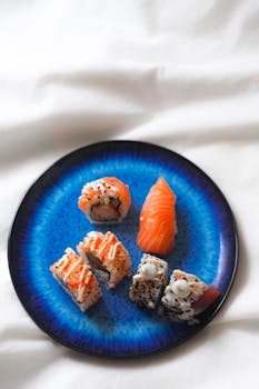 Top view of an elegant blue plate with assorted sushi pieces, perfect for gourmet dining.