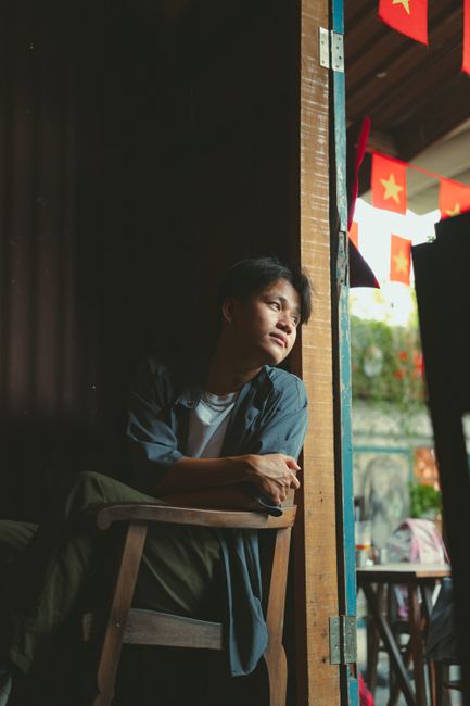 A person sitting by the doorway in Ho Chi Minh City, Vietnam, gazing outside.