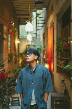 Portrait of a young man in a vintage alleyway with vibrant lighting in Ho Chi Minh City, Vietnam.