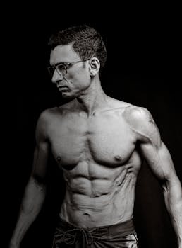 Black and white photo of a muscular man posing, showcasing fitness and strength.