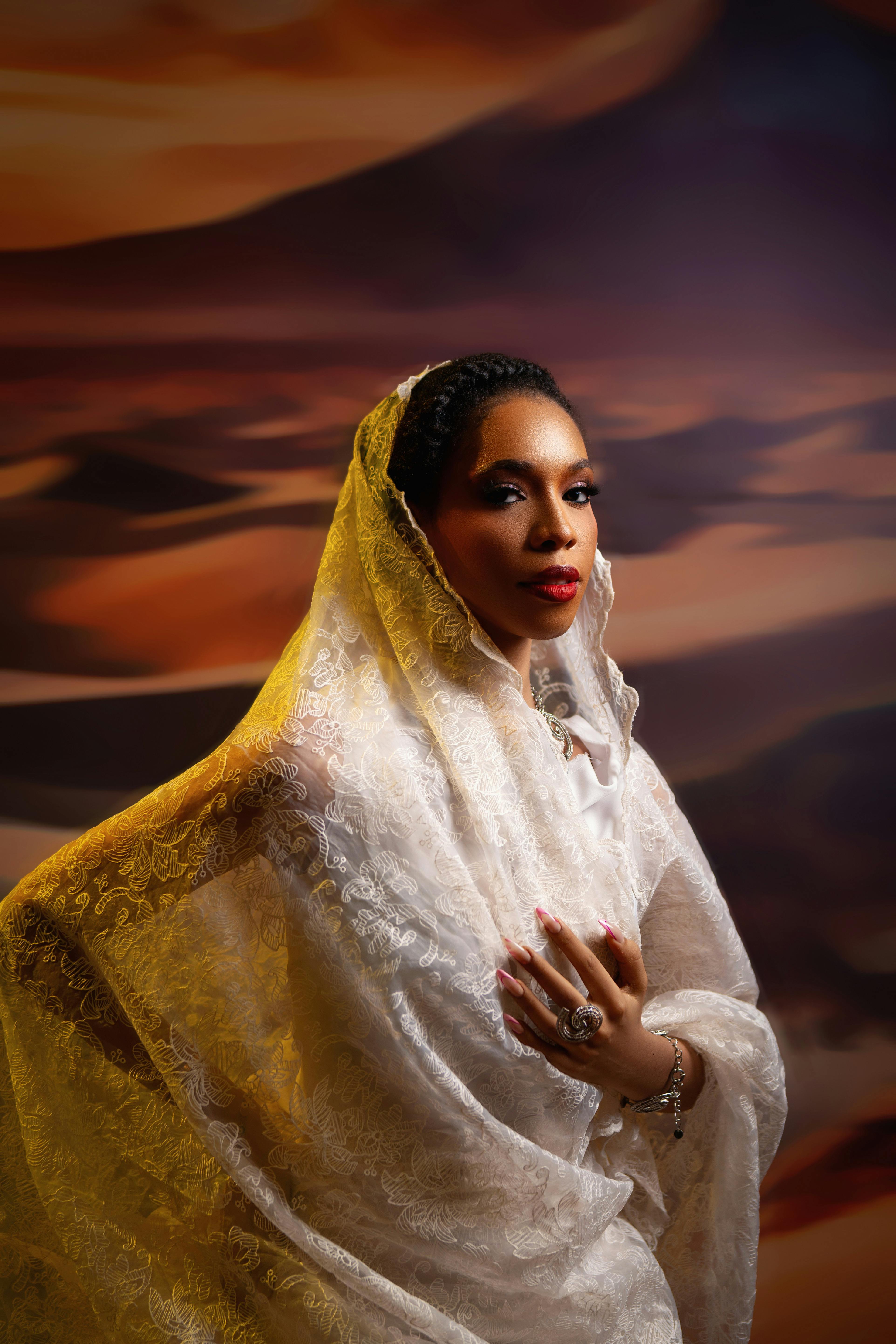 A portrait of a woman in traditional Nigerian attire with a desert-inspired backdrop.