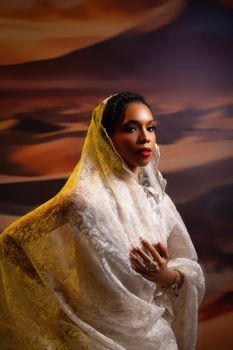 A portrait of a woman in traditional Nigerian attire with a desert-inspired backdrop.