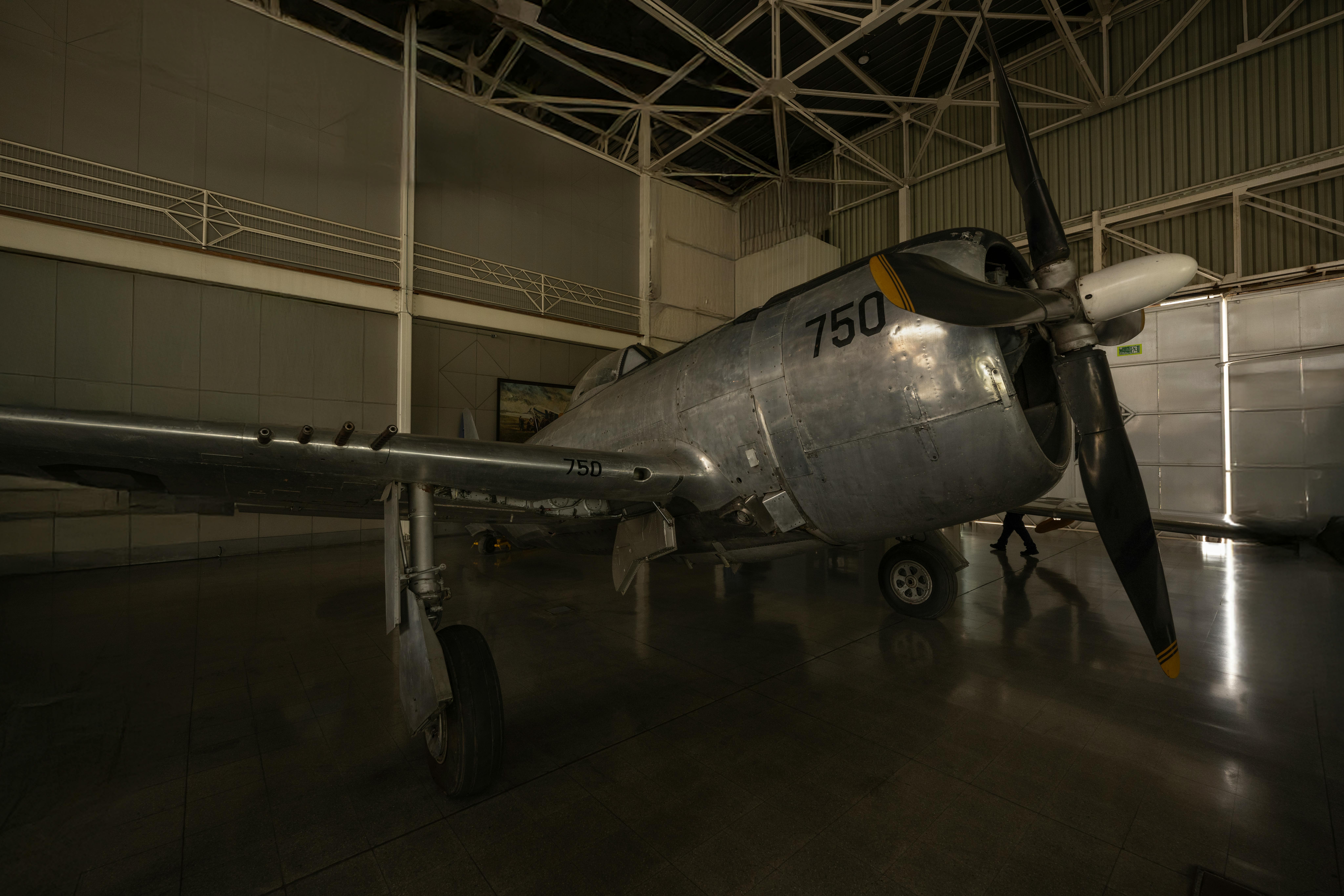 Historic aircraft displayed in a dimly lit museum hangar showcasing vintage aviation history.