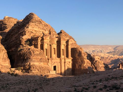 Free The Al-Deir Monastery in Petra illuminated by sunset light, showcasing ancient architecture. Stock Photo
