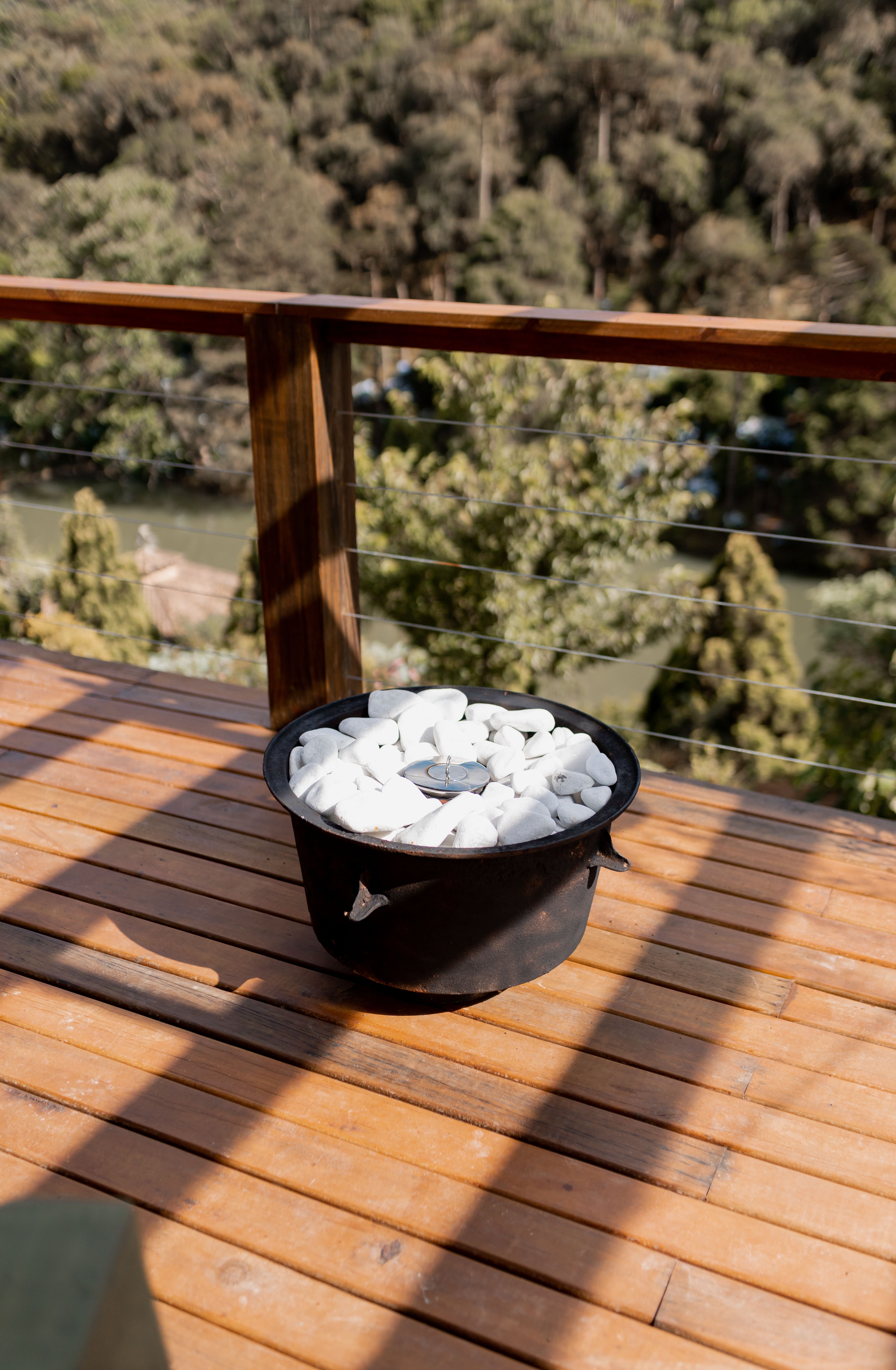 Small ethanol tabletop fire pit on a side table on a small apartment patio, glowing at dusk