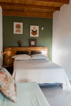 A stylish bedroom with modern art, wooden accents, and a cozy atmosphere.