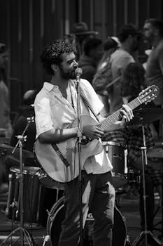 Outdoor performance of a musician playing guitar and singing on the street.