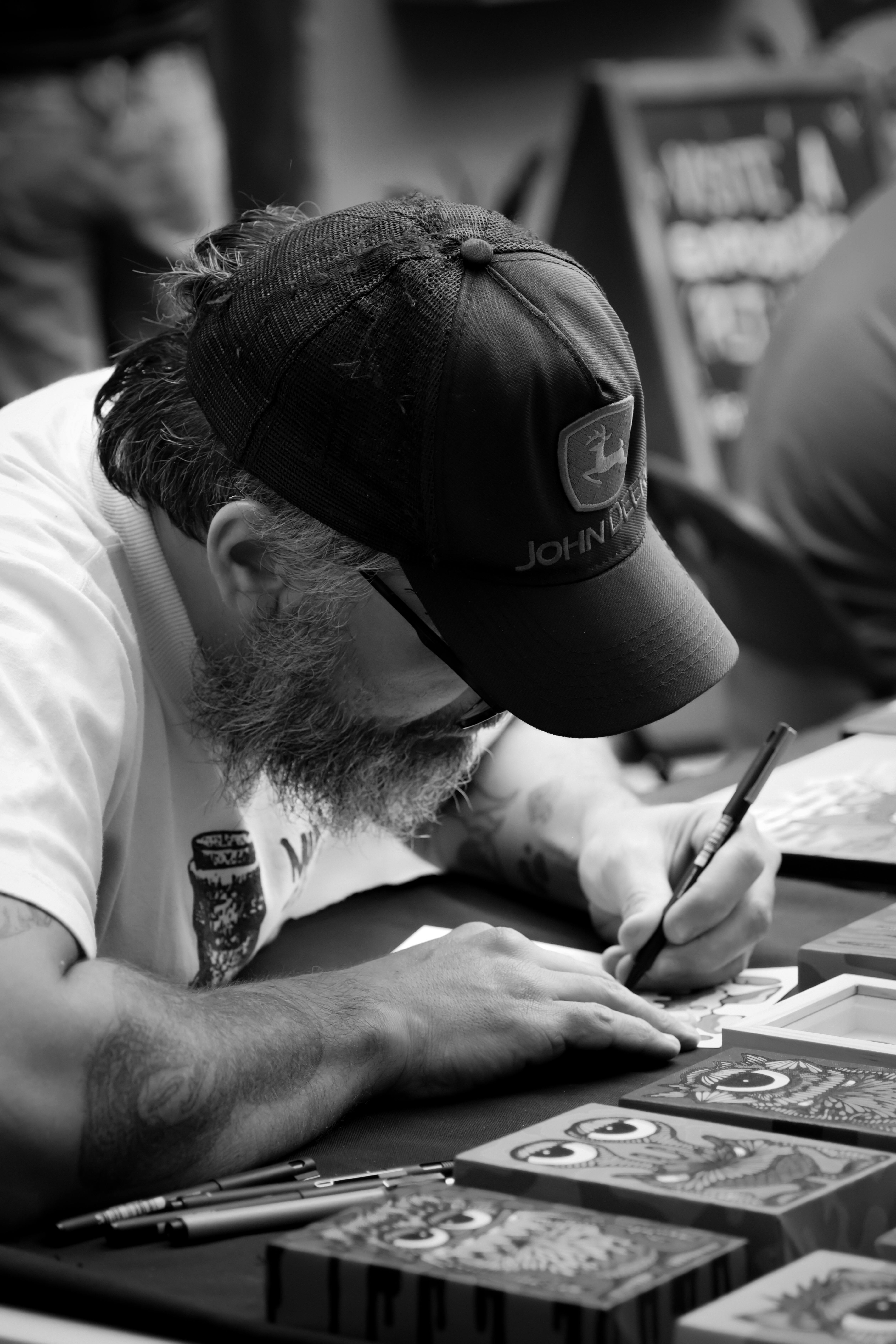 Artist focused on drawing detailed sketches at a desk in monochrome.