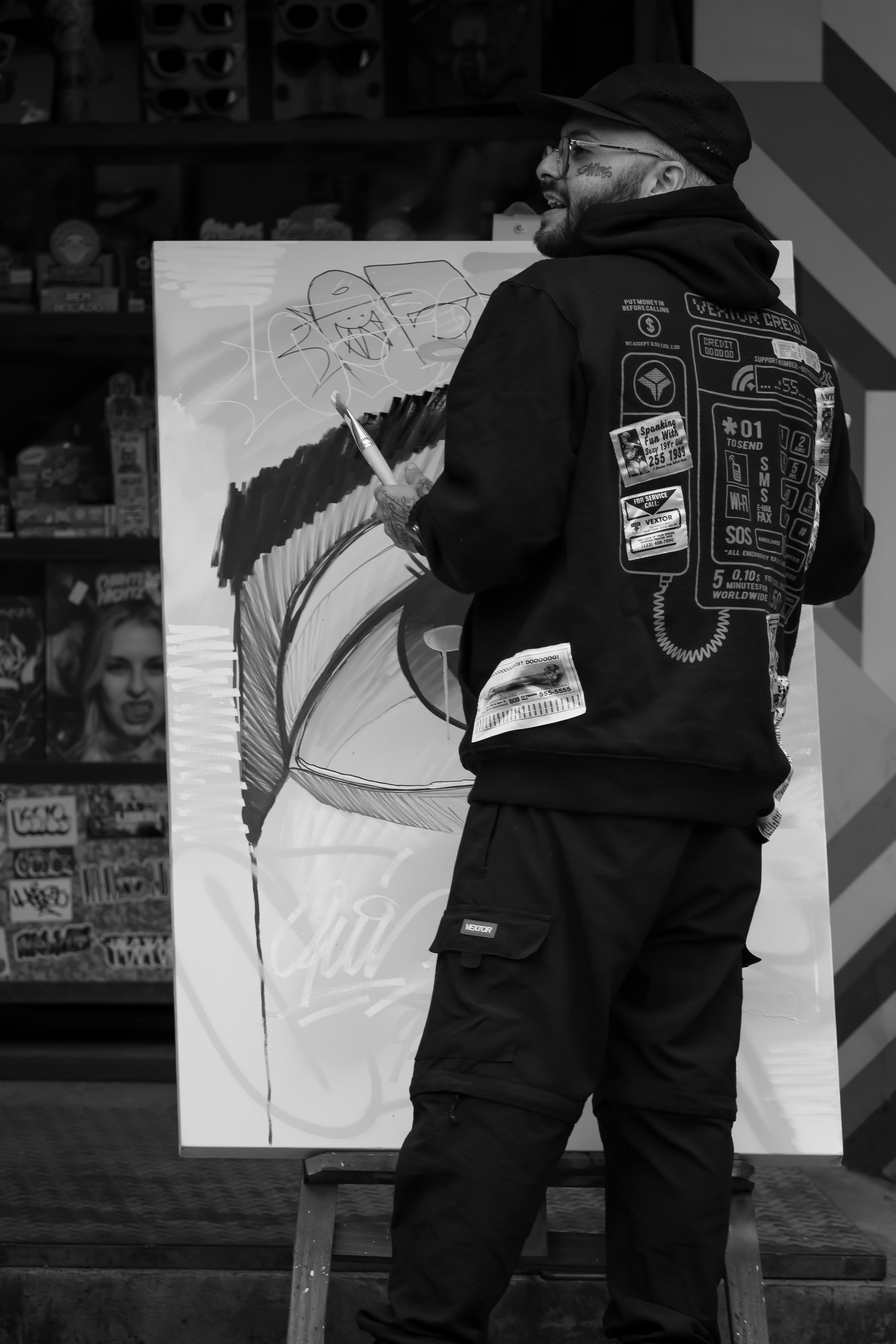 Street artist working on a canvas, adding vibrant street art elements outdoors.