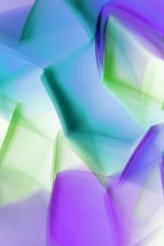 A dynamic abstract pattern featuring vibrant geometric shapes in shades of blue, green, and purple.
