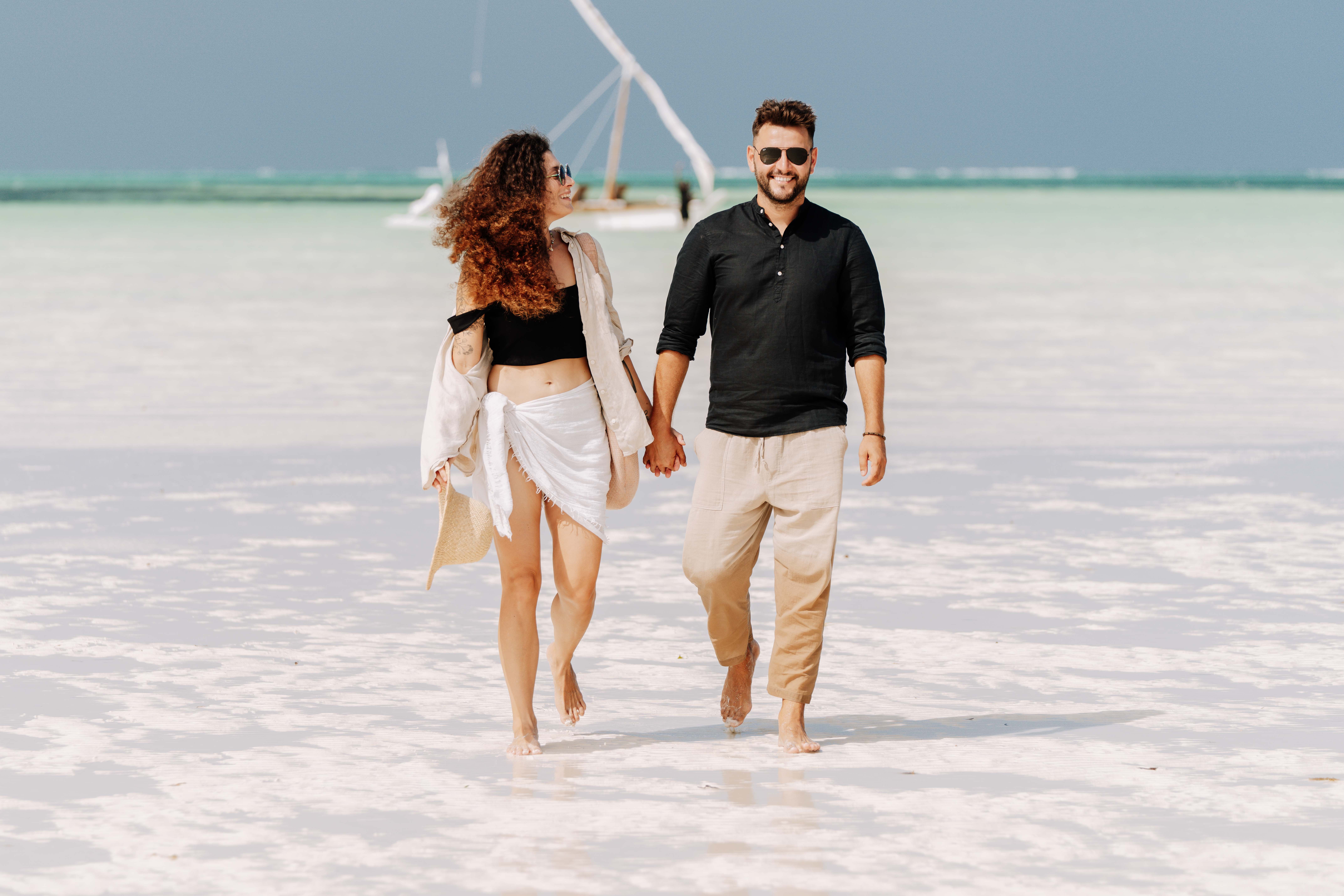 Couple enjoying a romantic walk on Zanzibar's pristine beach. Couple enjoying a romantic walk on Zanzibar's pristine beach.