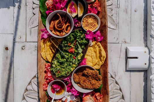 A colorful platter featuring diverse local Zanzibar dishes and flowers.