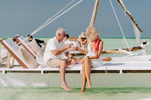 Elderly couple enjoying a serene boat ride on the turquoise waters of Zanzibar.