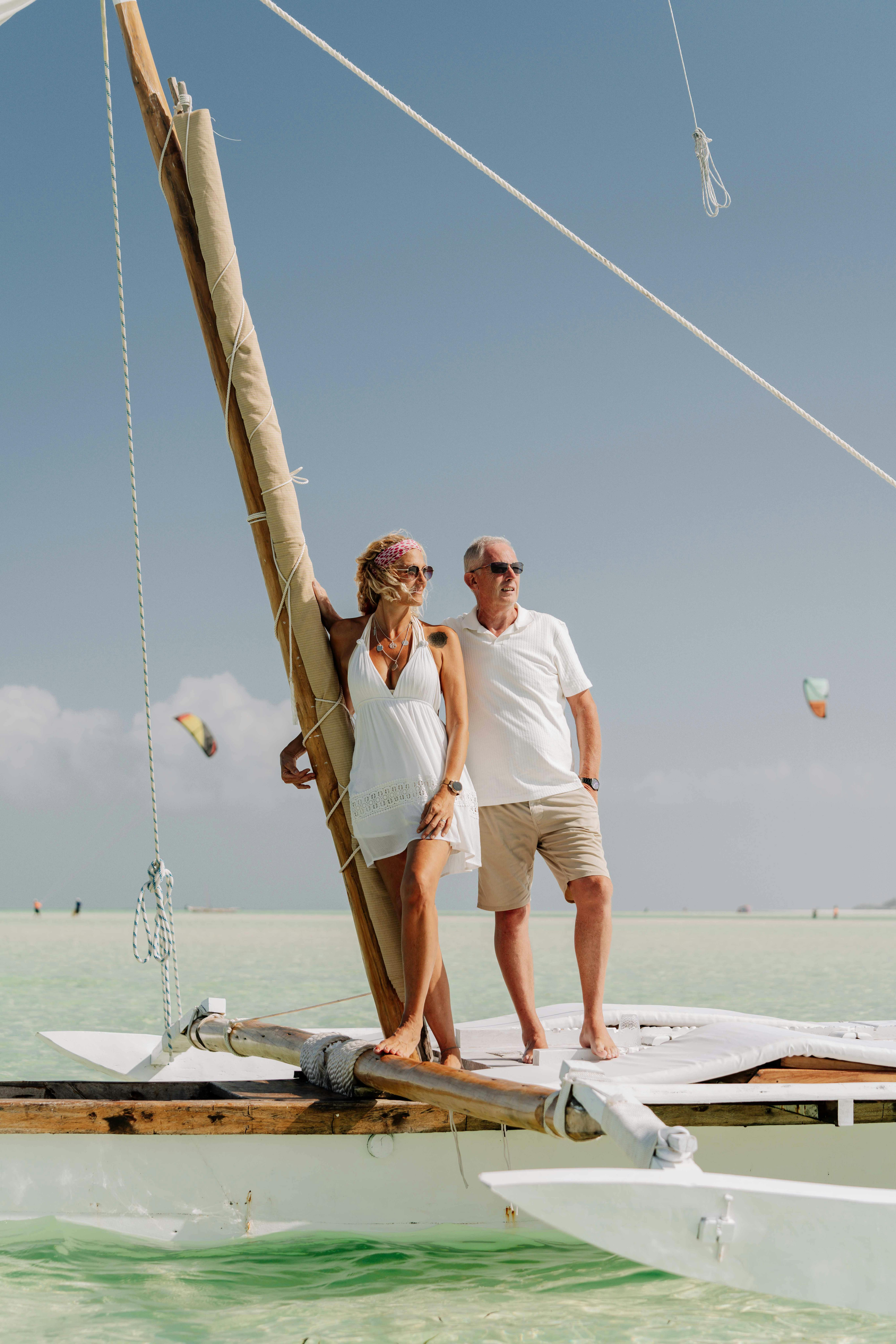高级夫妇在桑给巴尔海岸享受单帆帆船之旅，沐浴在宁静的夏日氛围中
