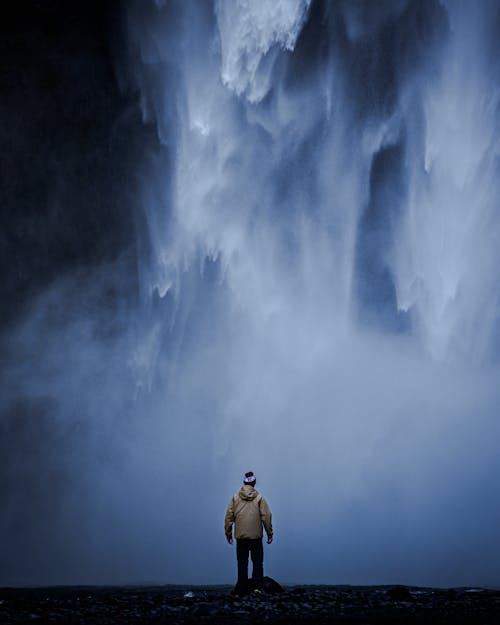 Man Standing Near Waterfalls