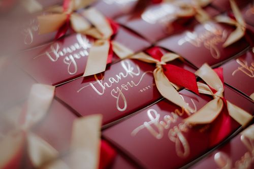 Free A close-up of beautifully wrapped red gift boxes with 'Thank you' tags and golden ribbons. Stock Photo