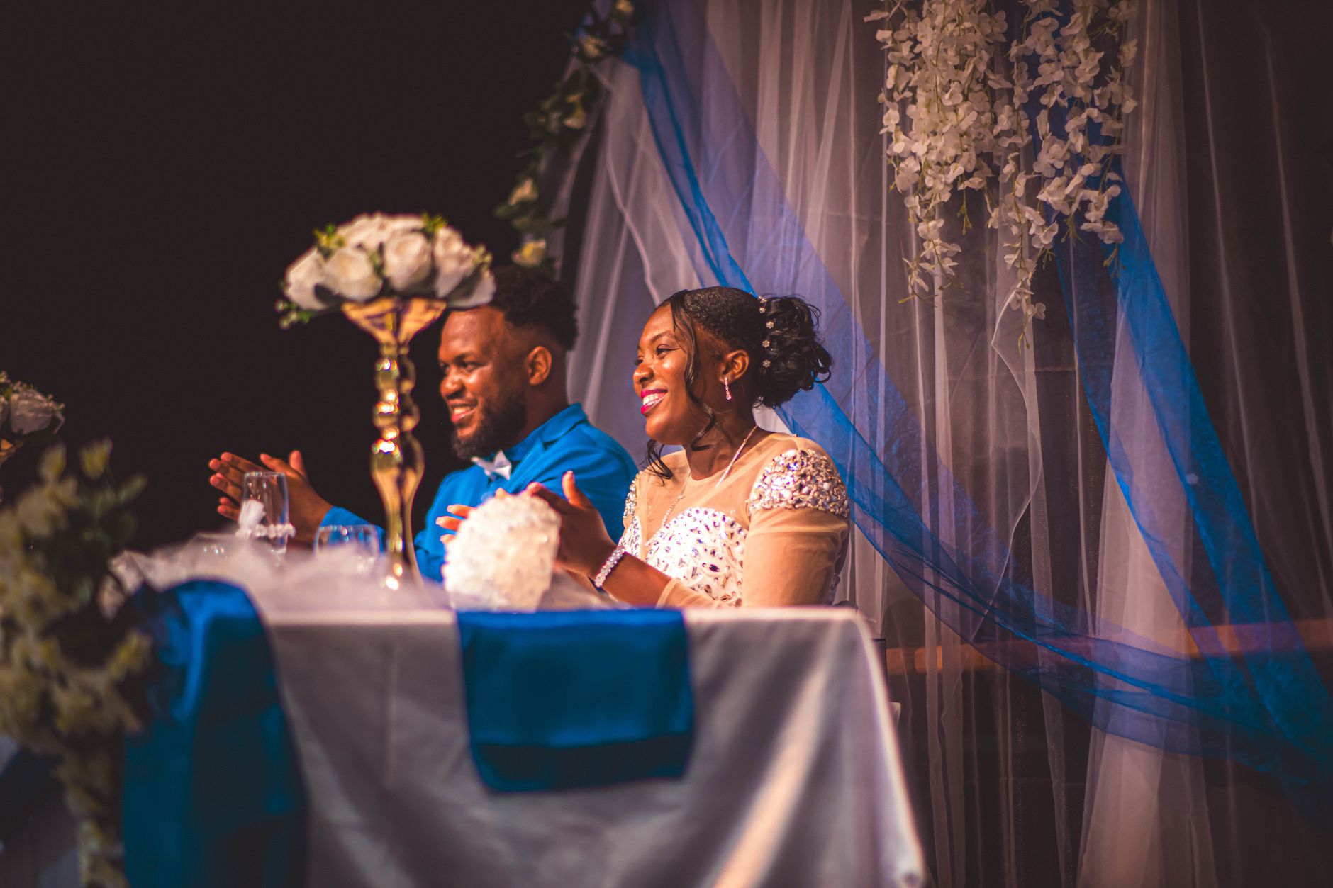 Happy couple celebrating their wedding reception with a joyful smile and elegant decor.