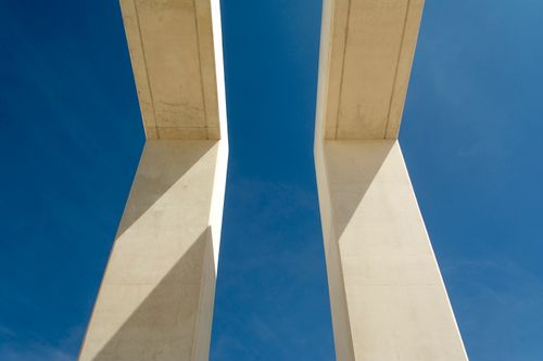 Free A striking view of concrete supports against a clear blue sky, showcasing modern architecture. Stock Photo