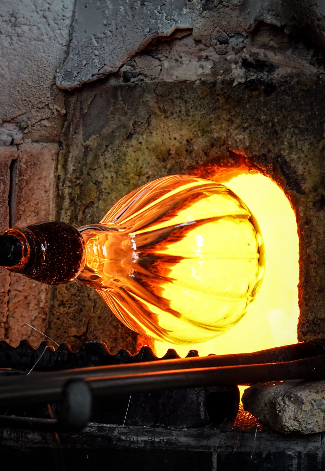 Molten glass glowing orange inside a reheating furnace — photo by Magda Ehlers on Pexels