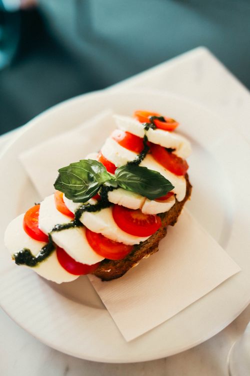 Free Delicious Caprese sandwich with ripe tomatoes, fresh mozzarella, and basil pesto. Stock Photo