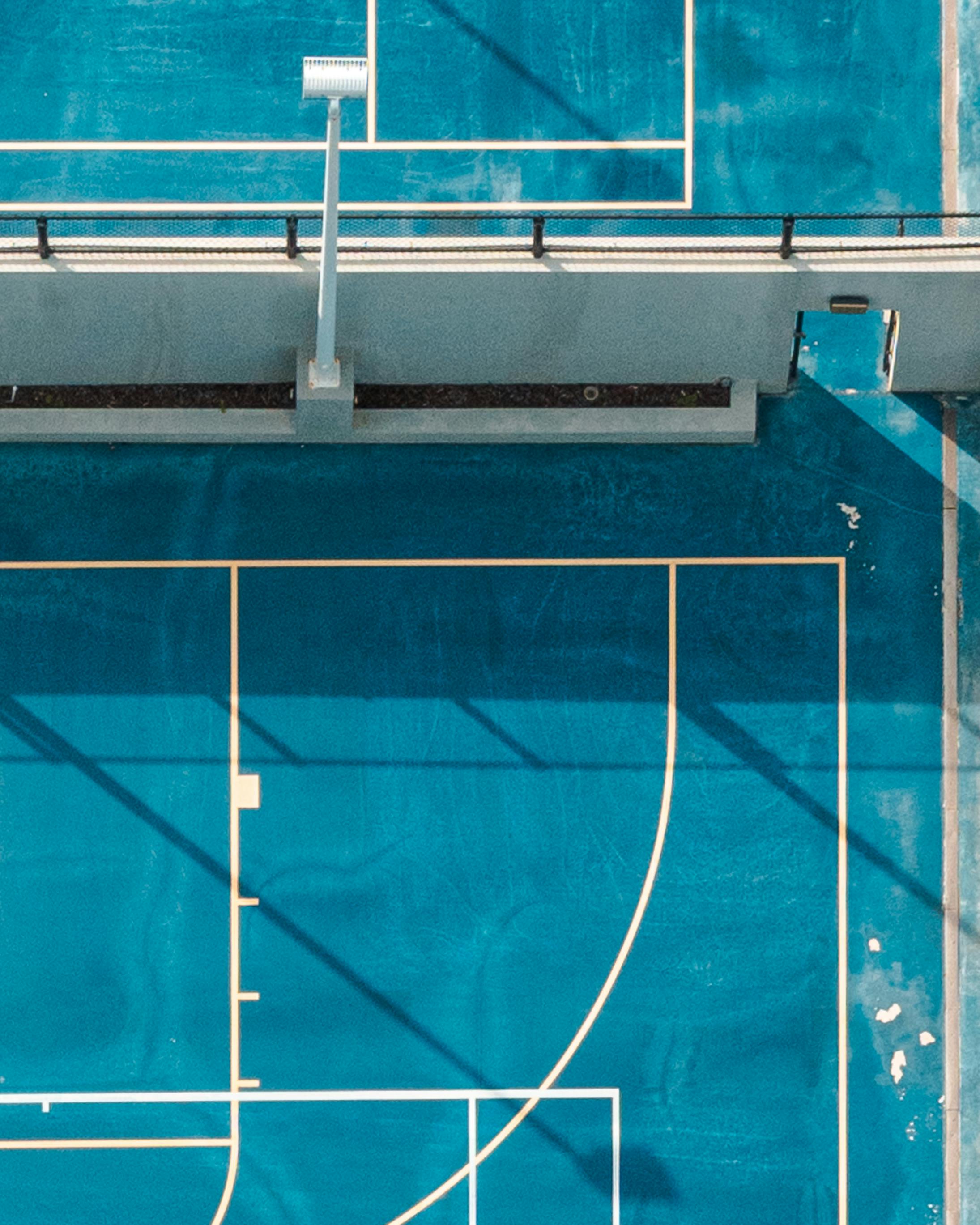 Aerial photo emphasizing the unique geometry of an empty blue basketball court in Miami.
