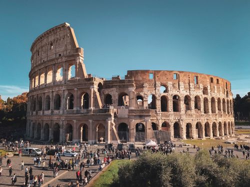 Free Historic Colosseum in Rome with tourists, showcasing ancient Roman architecture. Stock Photo