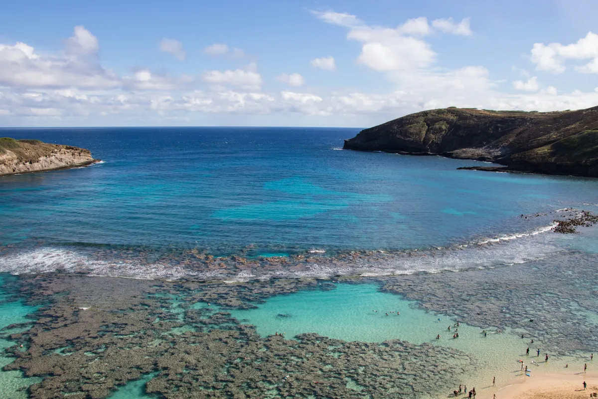 Snorkelers in the clear turquoise water over the reef at Hanauma Bay, Oahu
