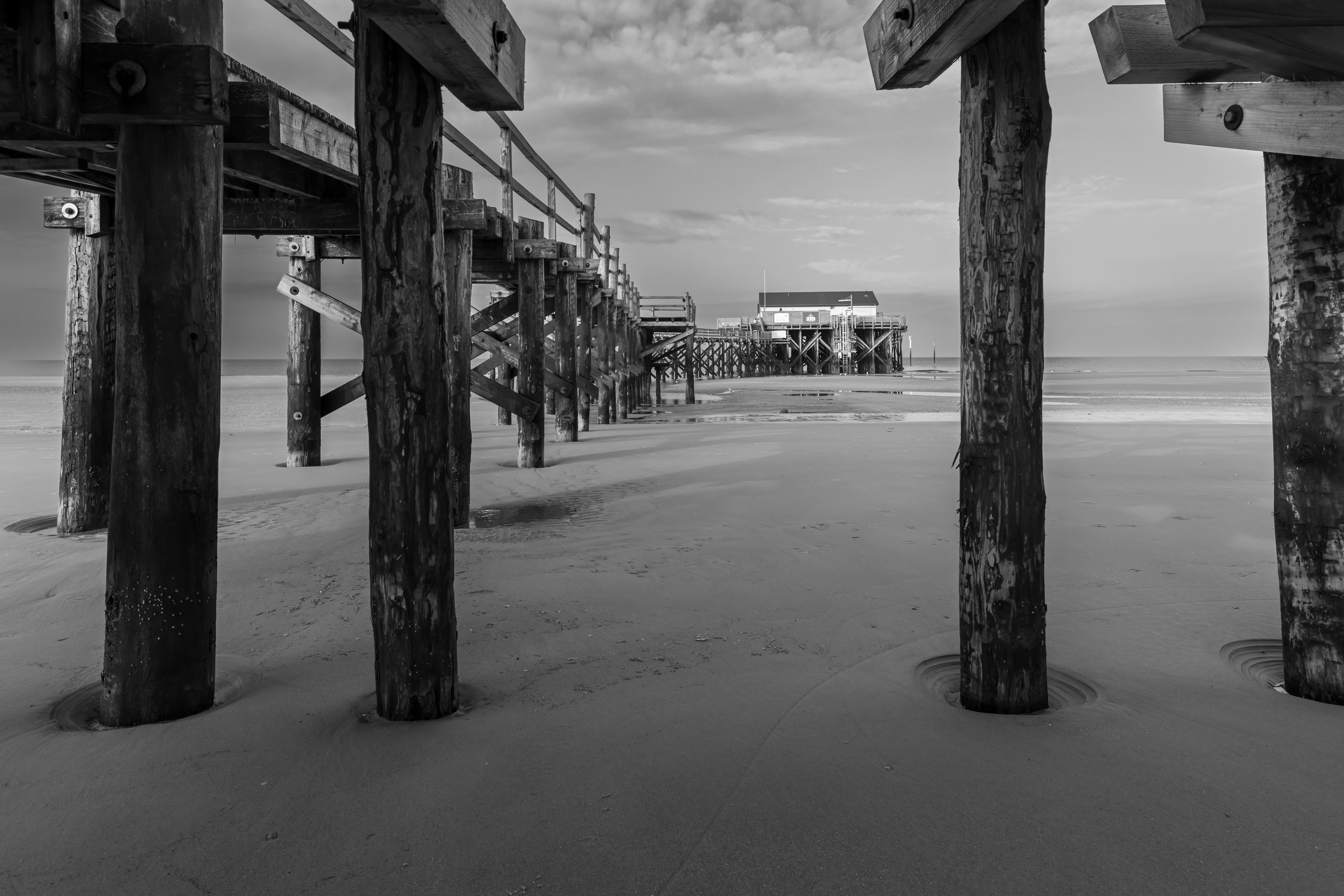 black and white beach pier at sankt peter ording