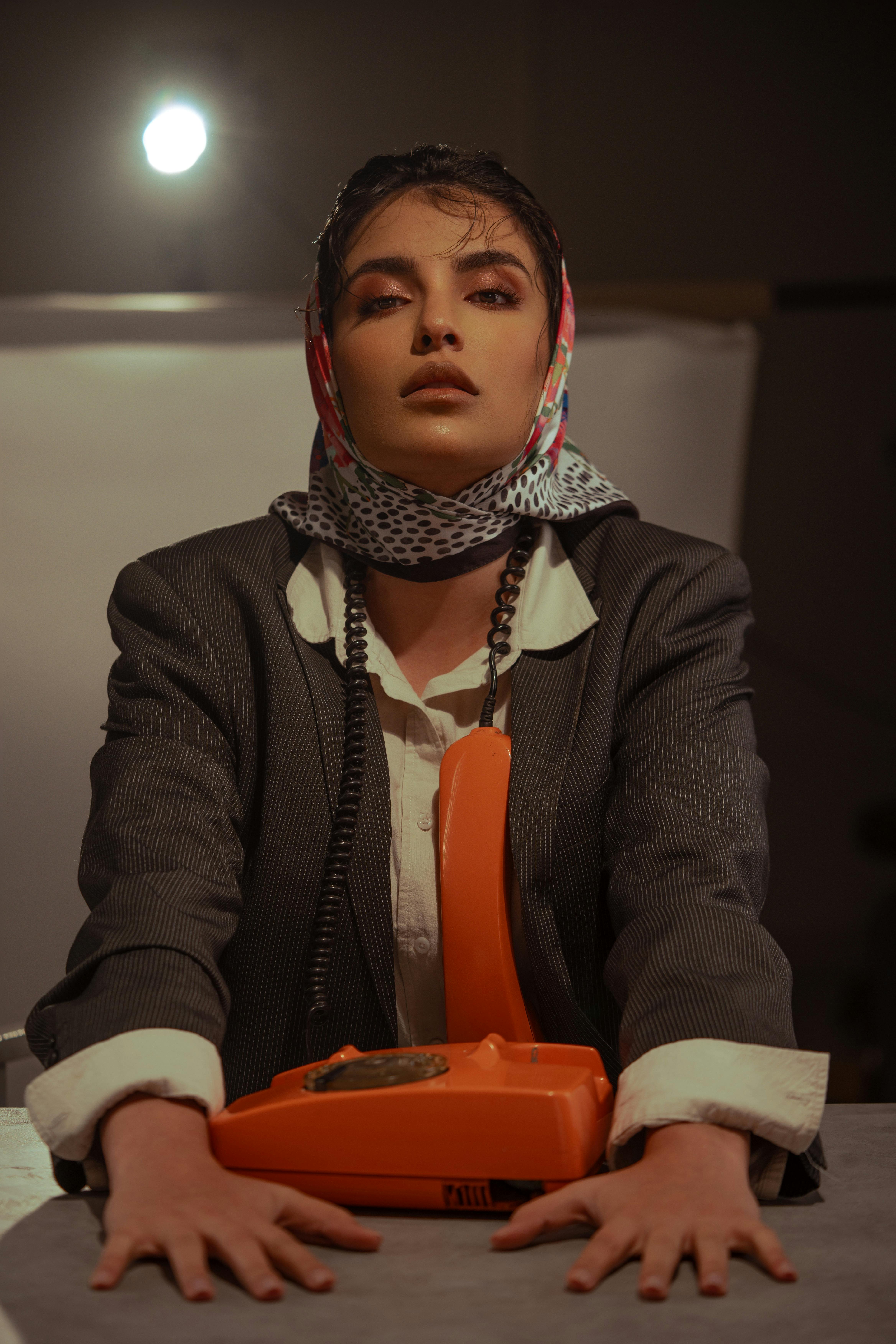 stylish woman with vintage orange telephone