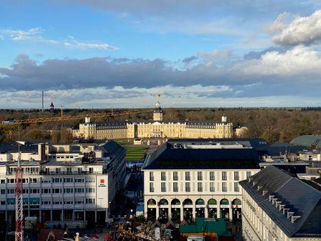 Aerial view of Karlsruhe Palace surrounded by city architecture and trees.