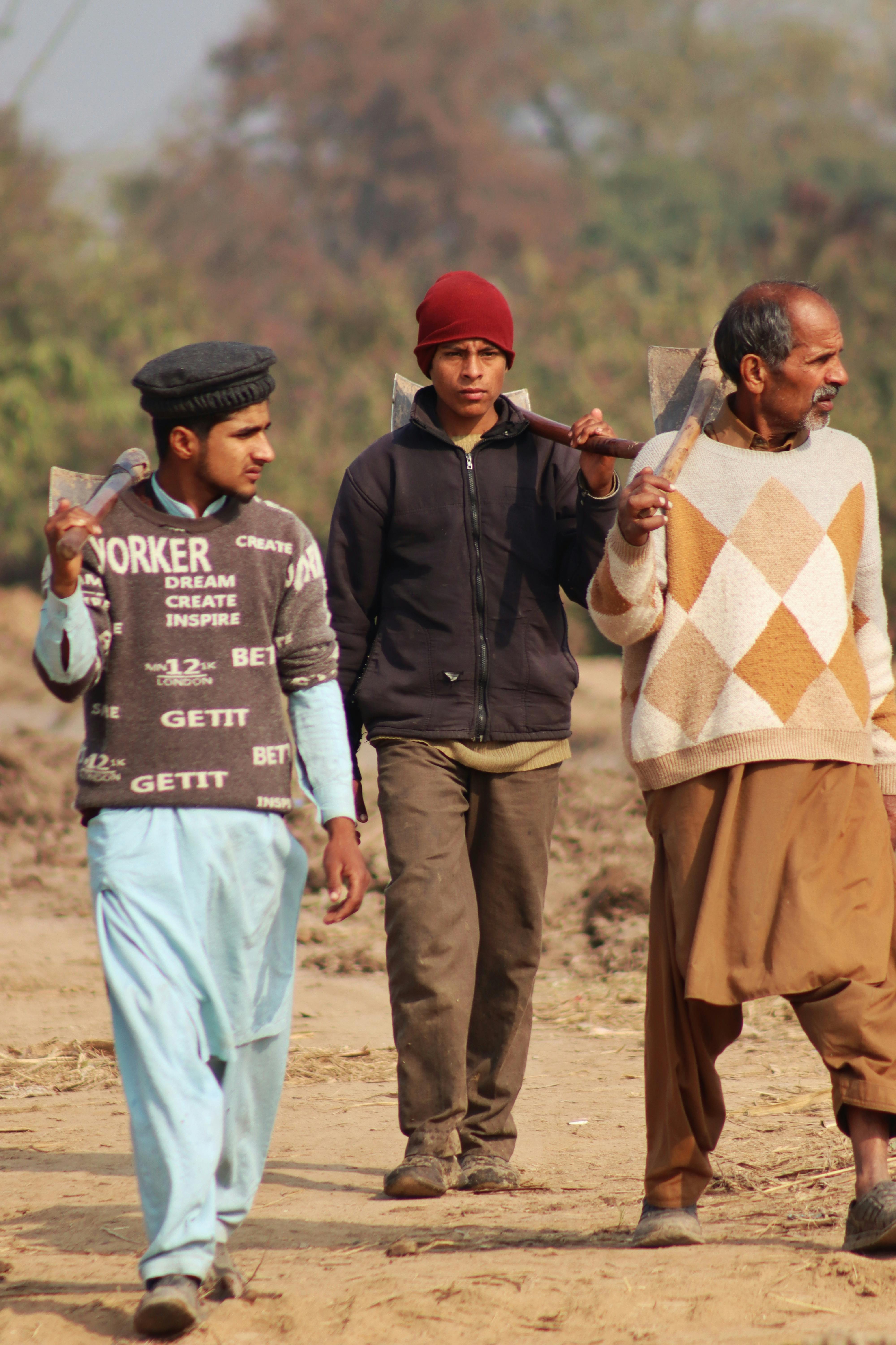 three farmers walking in lahore fields