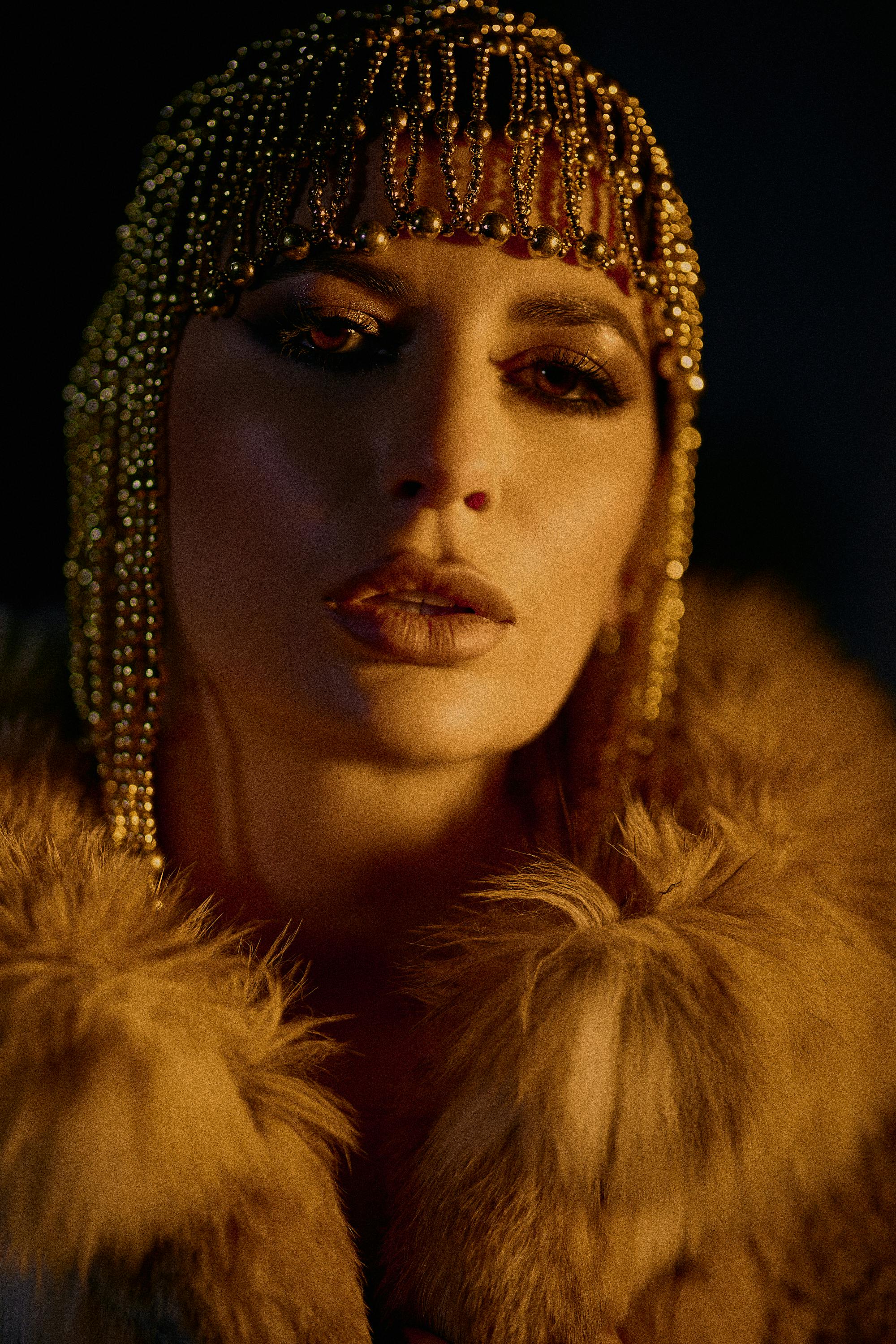 Elegant woman wearing a beaded headpiece and fur coat, showcasing vintage glamor.