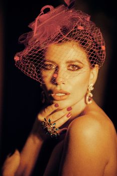 Vintage style portrait of a woman with a vibrant pink hat and classic expression.