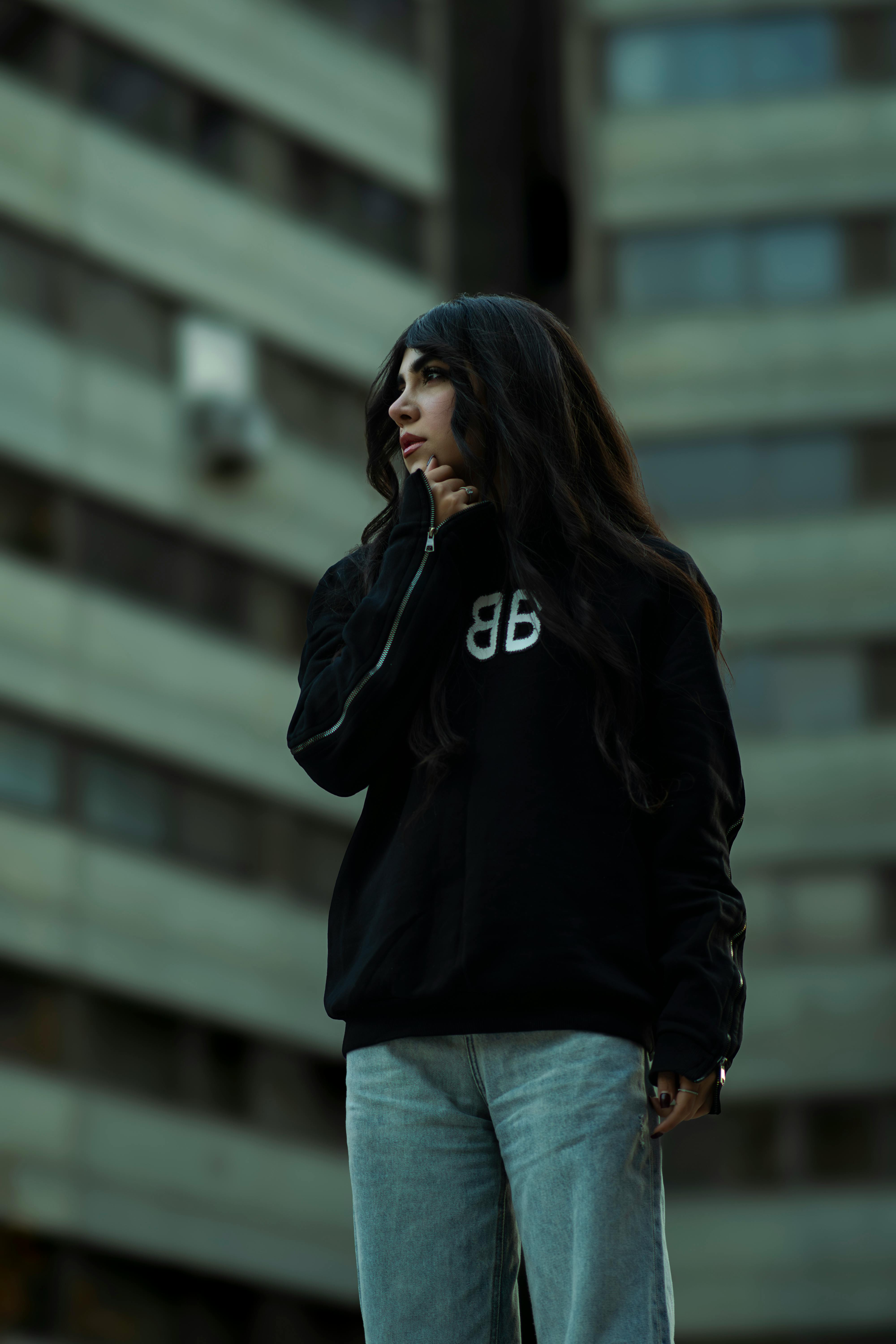 Portrait of a woman in a casual outfit standing in front of modern architecture in Tehran, Iran.