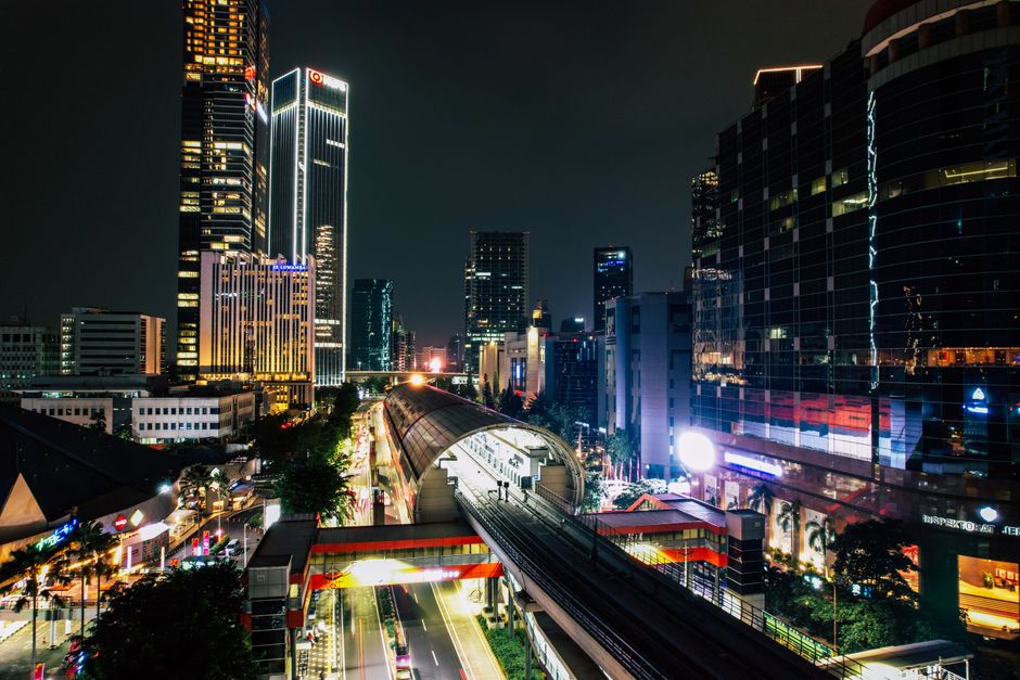 Illuminated skyline and train tracks in South Jakarta's Kuningan area at night.