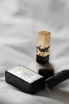 Yves Saint Laurent lipstick and packaging on a minimalist grey background.