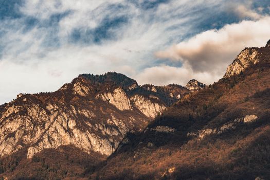 Dramatic view of a rocky mountain range with a cloudy sky creating a moody atmosphere.