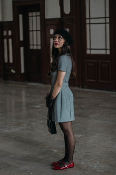 A fashionable woman in retro attire stands indoors at a historic Istanbul location.