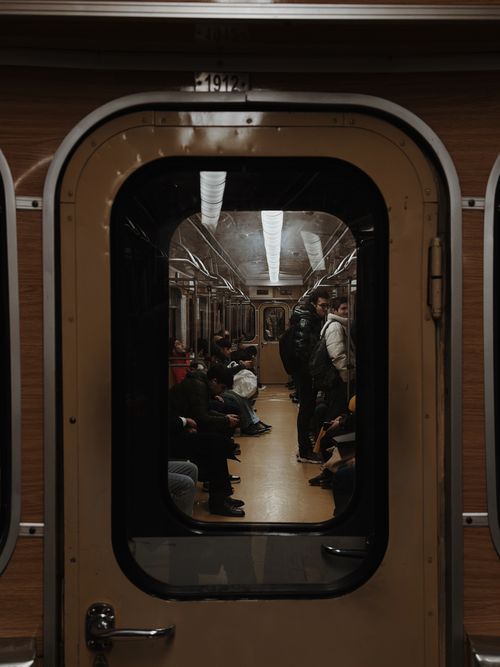 Free Moody interior shot of passengers inside a vintage subway train, captured through an open door. Stock Photo